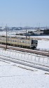 雪景色の中を走る211系